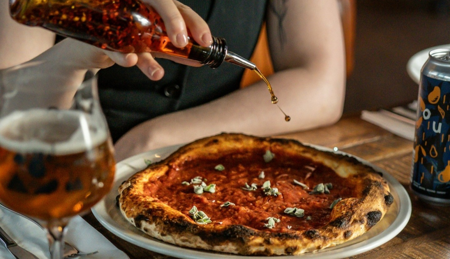 Drizzling chilli oil on a pizza